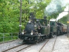 Ein Zug gezogen von drei Dampfloks fährt in den Bahnhof Chamby ein